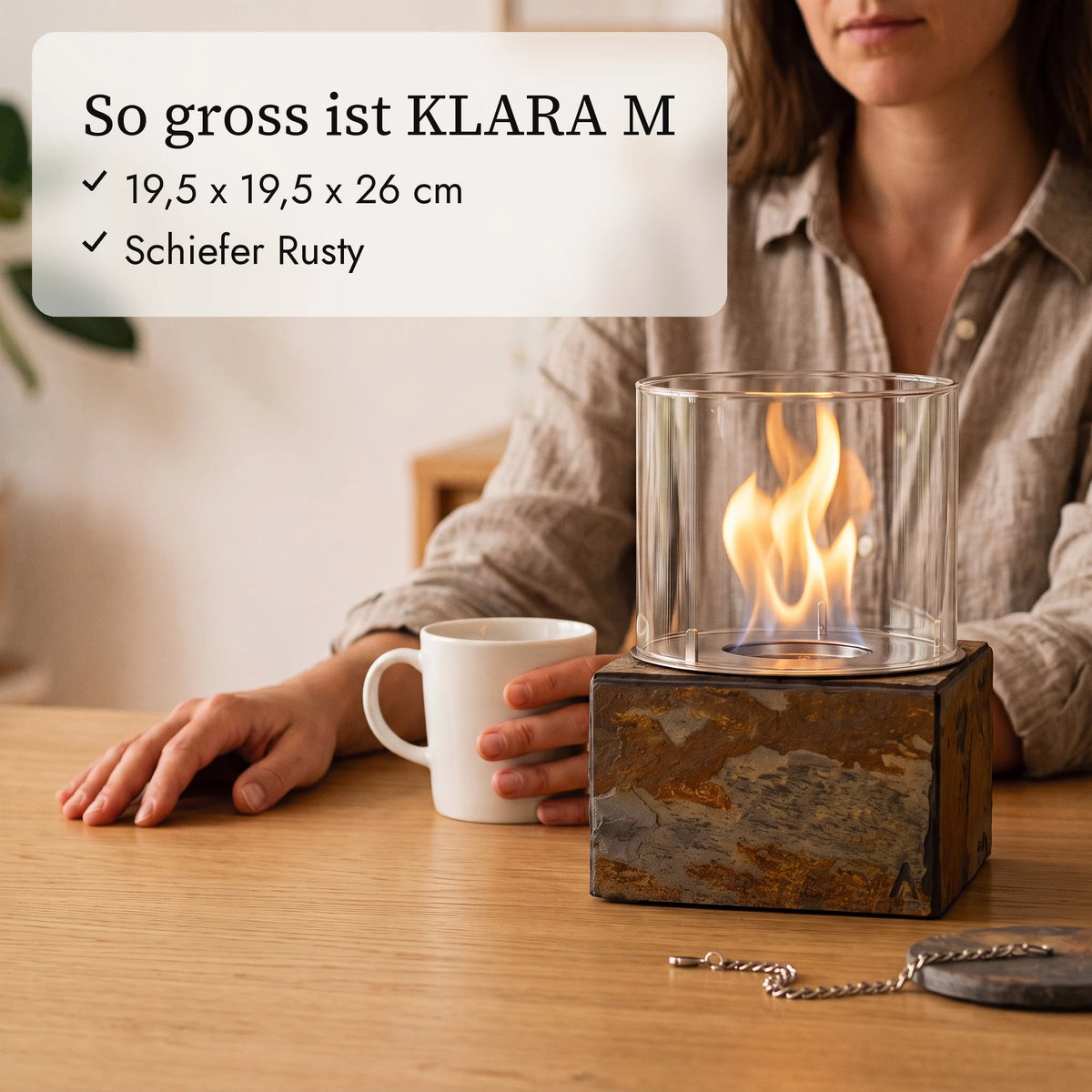 So gross ist KLARA M: 19,5 x 19,5 x 26 cm neben Kaffeetasse und Hand (KI-Inhalte)