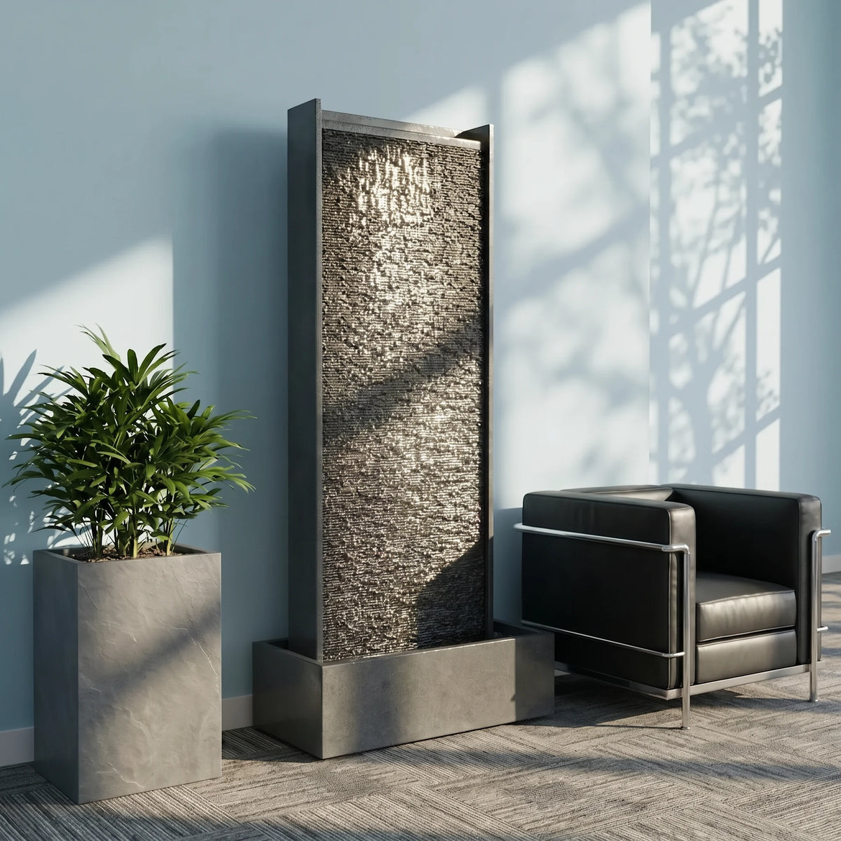 Wasserwand HARMONY aus Granitstein neben Pflanzgefäss und Lounge-Sessel in einem hellen Raum (KI-Inhalte)
