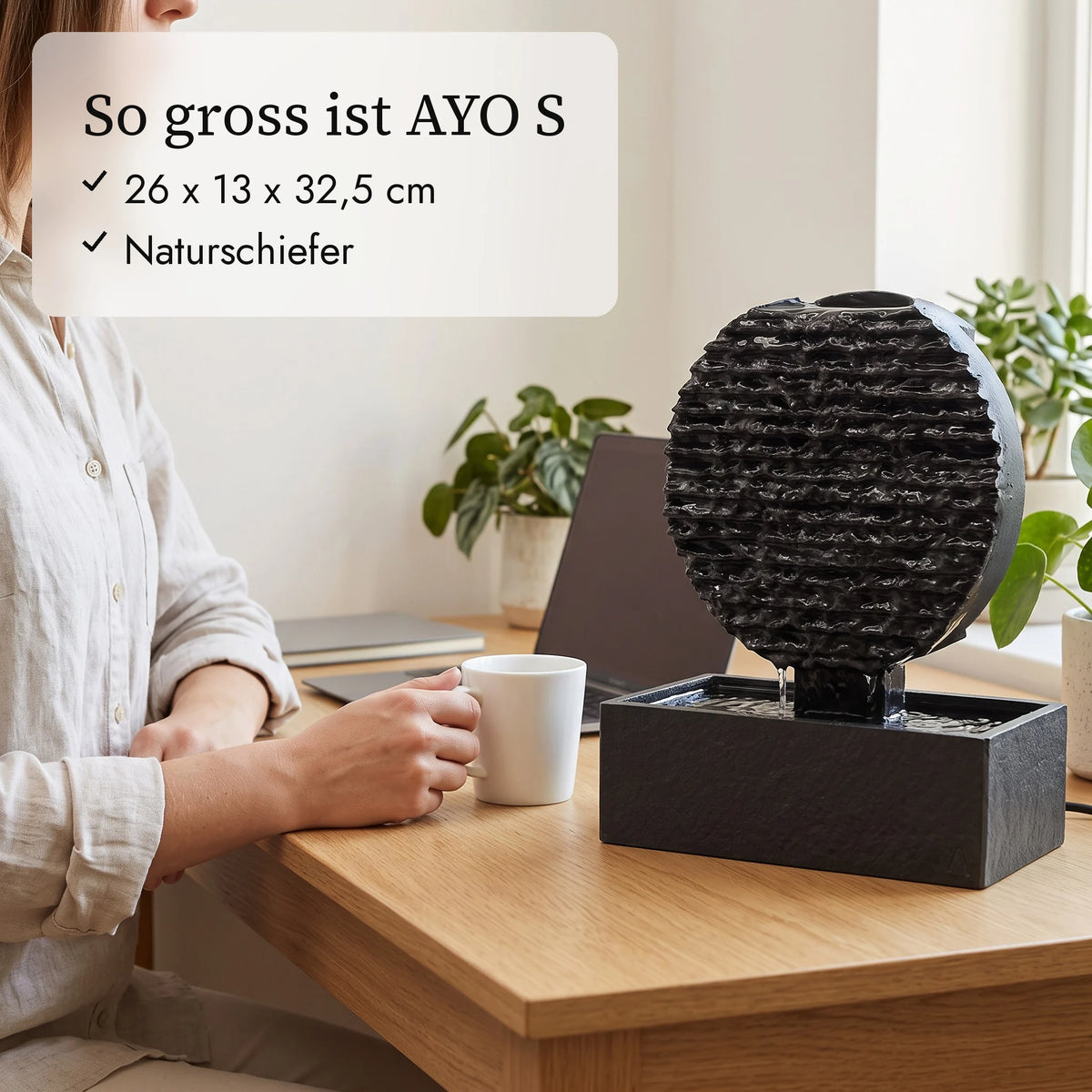 So gross ist AYO S: 26 x 13 x 32,5 cm neben Kaffeetasse und Hand (KI-Inhalte)