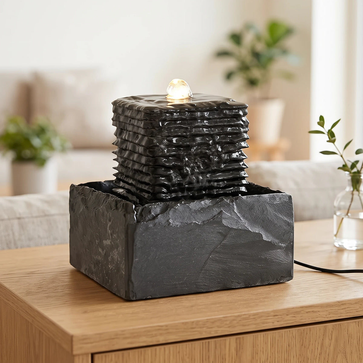 Zimmerbrunnen SHANTI aus Naturschiefer auf einem Sideboard im Wohnzimmer