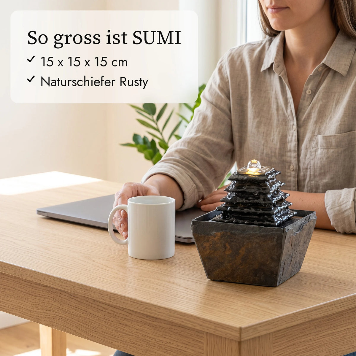 So gross ist SUMI: Zimmerbrunnen 15 cm neben Kaffeetasse und Hand (KI-Inhalte)