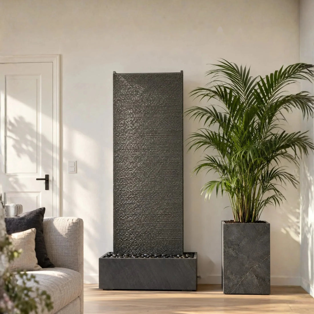 Waterwand EDEN GRANDE van graniet in de lichte woonkamer met plantenzuil (AI-inhoud)