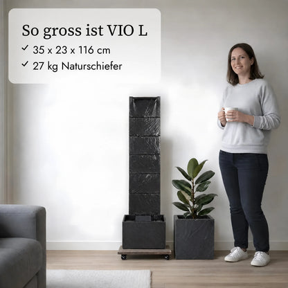 So gross ist die Wasserwand VIO L im Vergleich zu einer Person, daneben das Pflanzgefäss CUBI 31 (KI-Inhalte)
