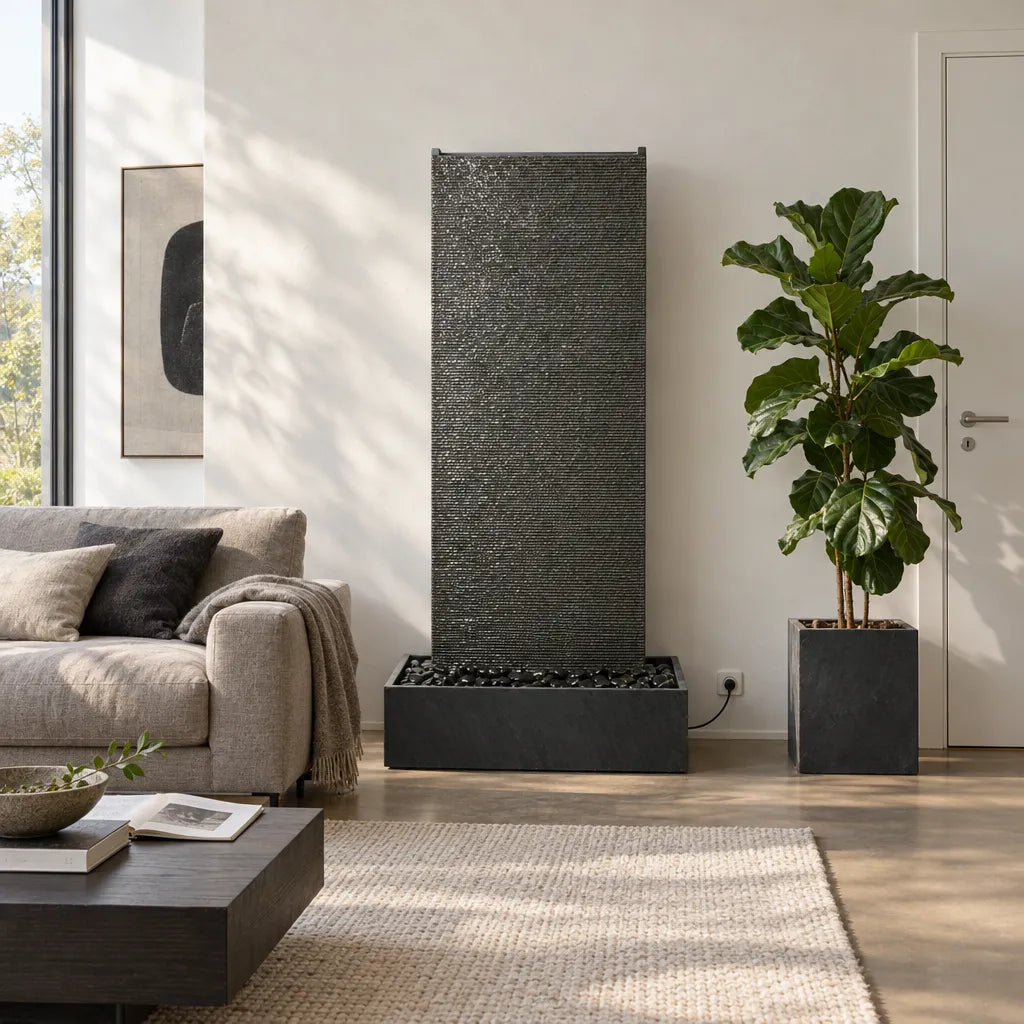 EDEN GRANDE Wasserwand aus Granitstein neben einem Sofa, daneben eine Zimmerpflanze im Pflanzgefäss - CLIMAQUA (KI-Inhalte)